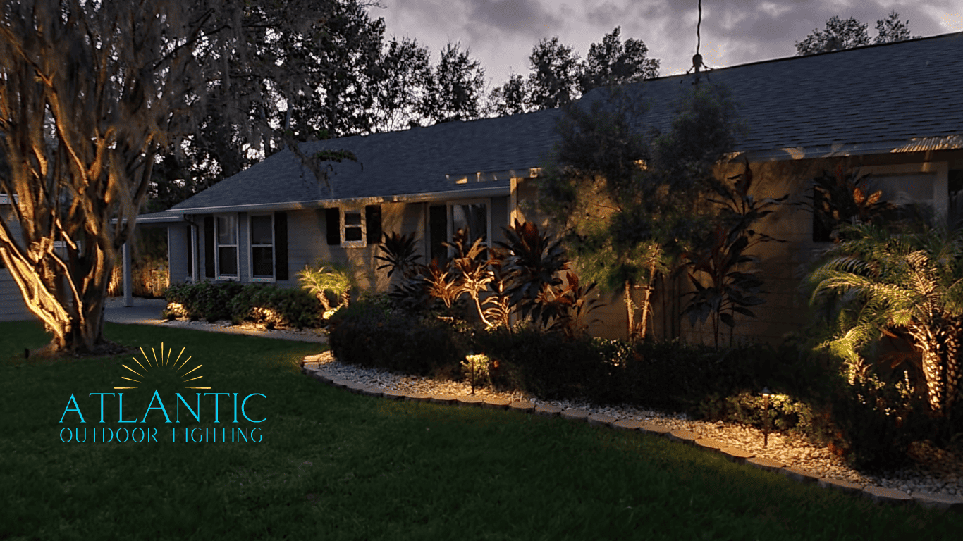 The front of a house with up-lit trimmed foliage and pebbles. Lightscaped by Atlantic Outdoor Lighting.